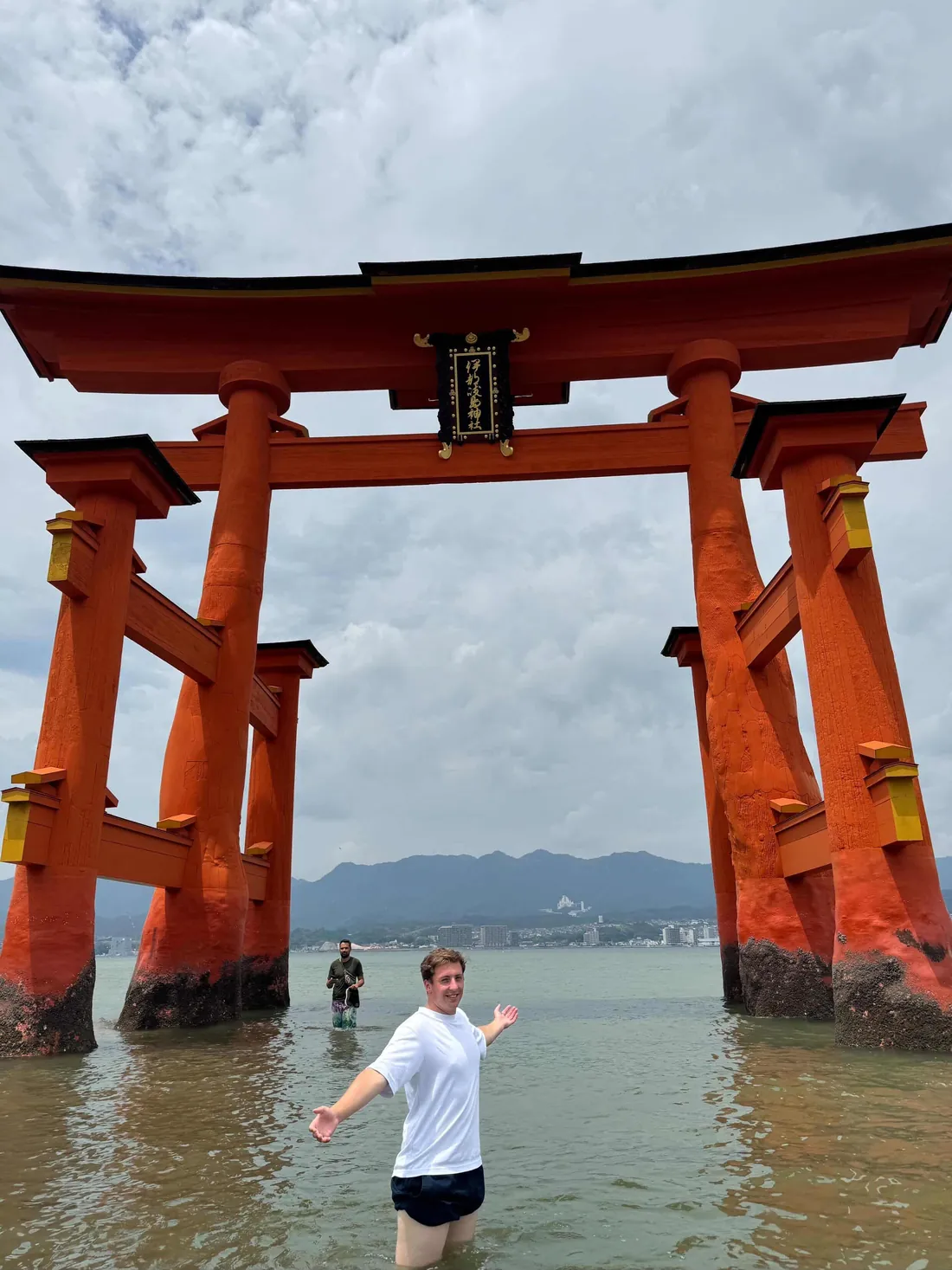 Jérémy dans l’eau devant le grand torii de Miyajima